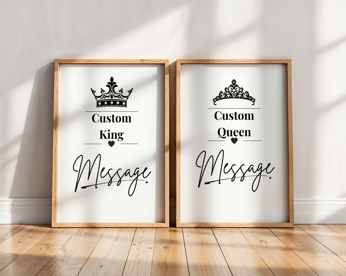 Two framed custom prints leaning against a white wall on a wooden floor. The left print says 'Custom King' with a crown graphic and the right print says 'Custom Queen' with a tiara graphic, both with blank message areas and light wood frames.