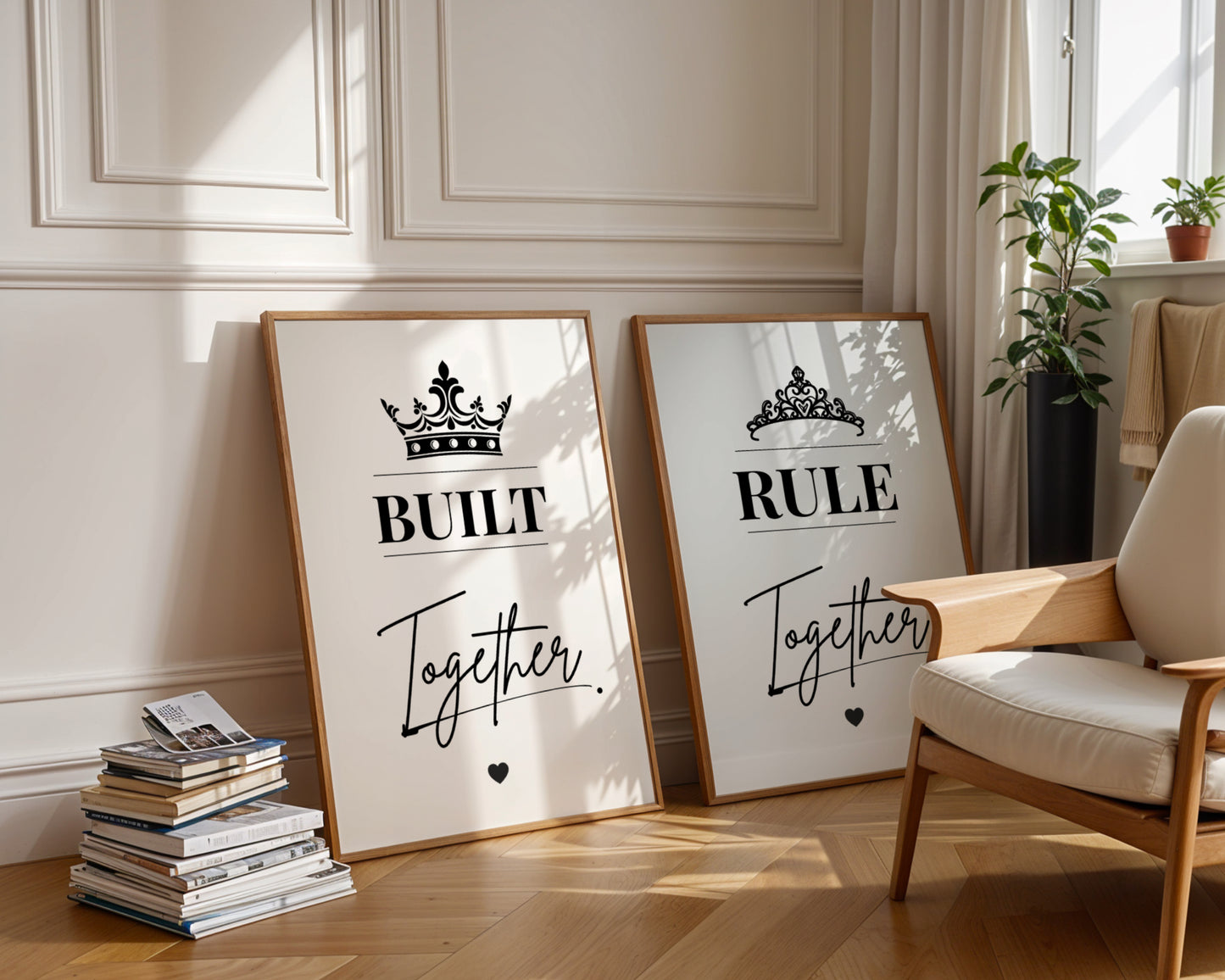 Two framed motivational art prints leaning against a cream paneled wall in a sunlit room. The left print says 'BUILT Together' with a crown graphic, and the right print says 'RULE Together' with a tiara graphic.