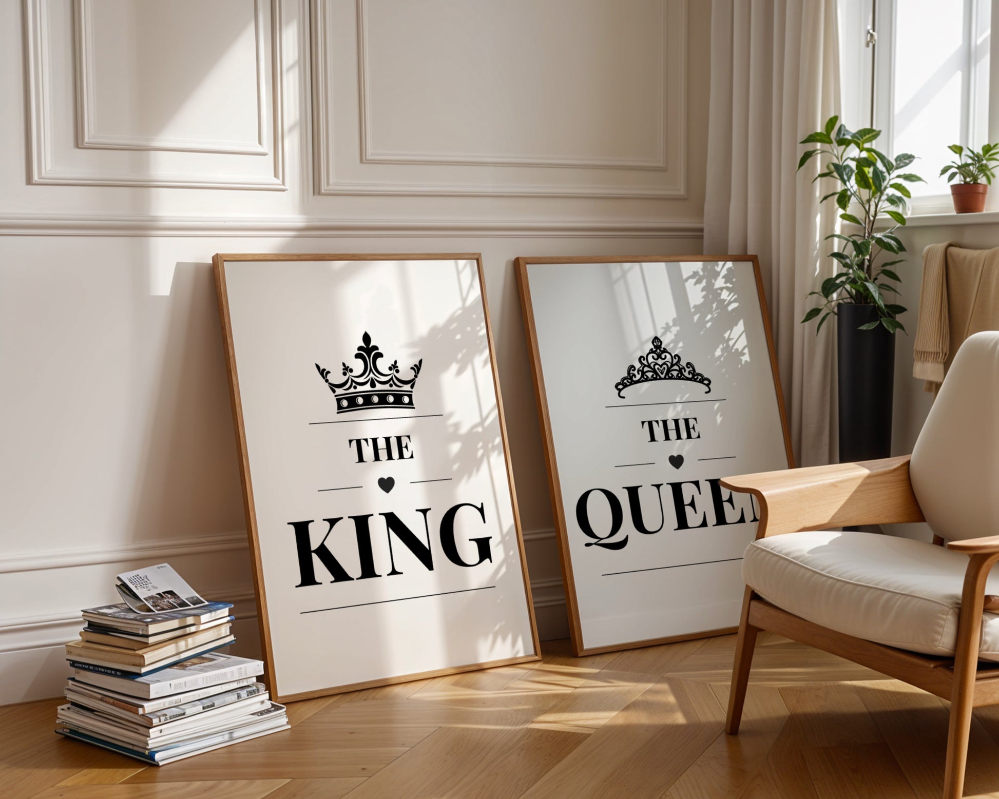 Two framed wall art prints leaning against a cream paneled wall in a sunlit room. The left print says “HER KING” with a crown graphic, and the right print says “HIS QUEEN” with a tiara graphic.