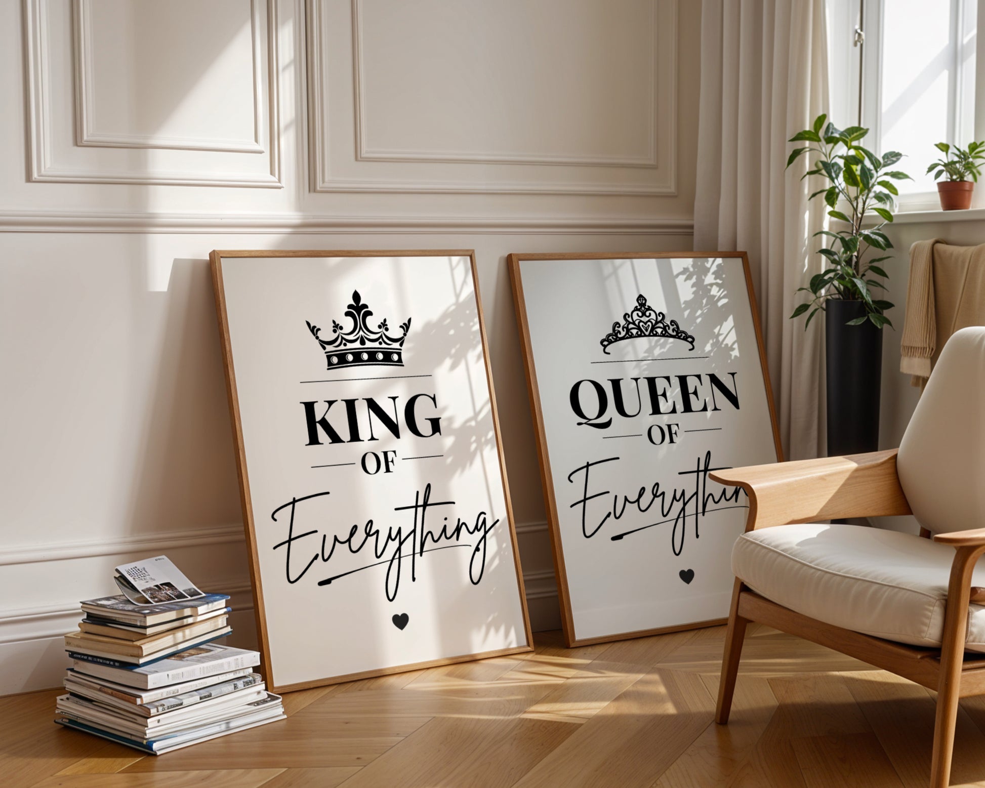 Two framed motivational wall art prints leaning against a cream paneled wall in a styled room. The left print says 'KING OF Everything' with a crown graphic, and the right print says 'QUEEN OF Everything' with a crown graphic.
