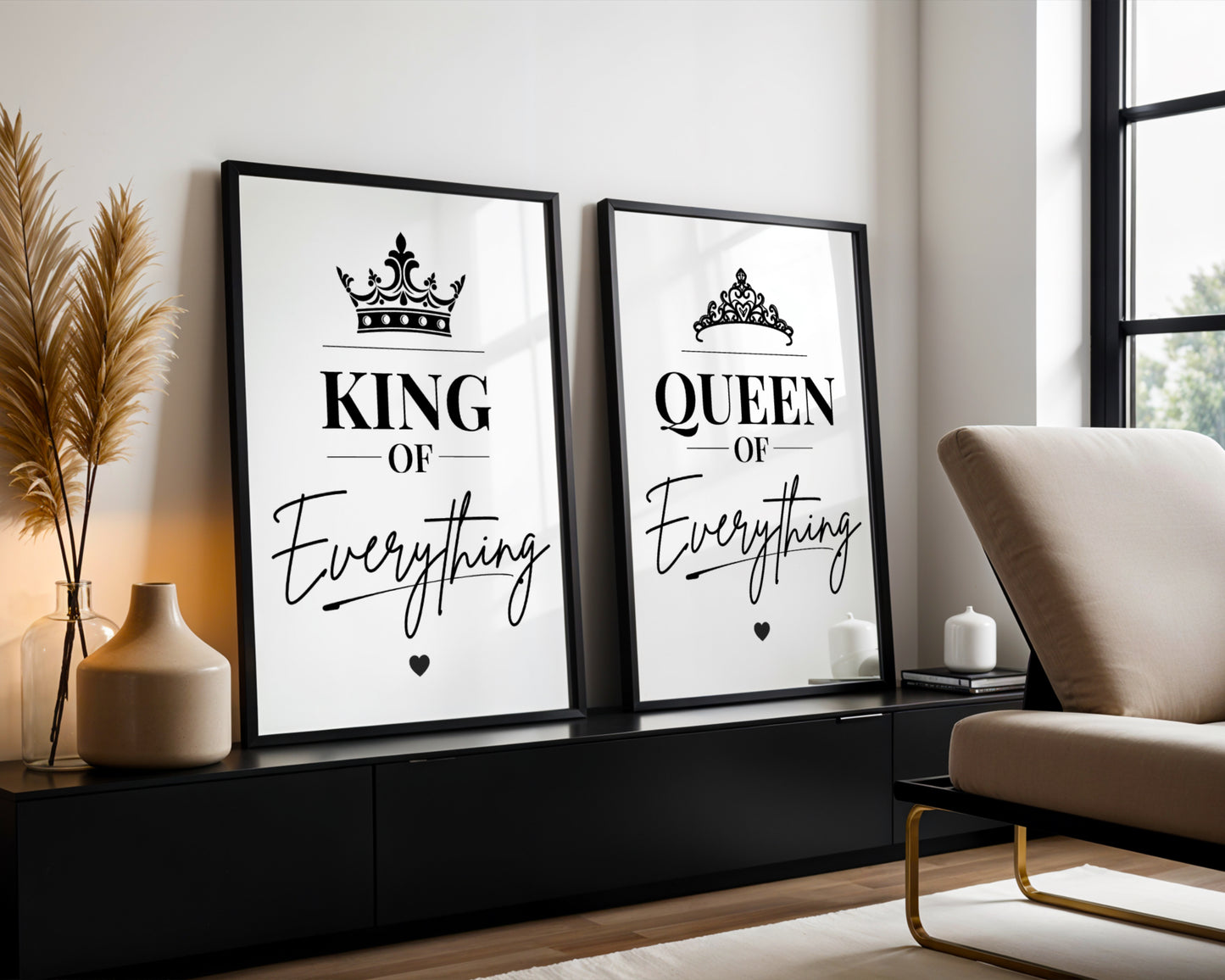 Two framed black-and-white decorative wall prints leaning against a wall in a modern room. The left print reads "KING OF Everything" with a crown graphic, and the right print reads "QUEEN OF Everything" with a tiara graphic.