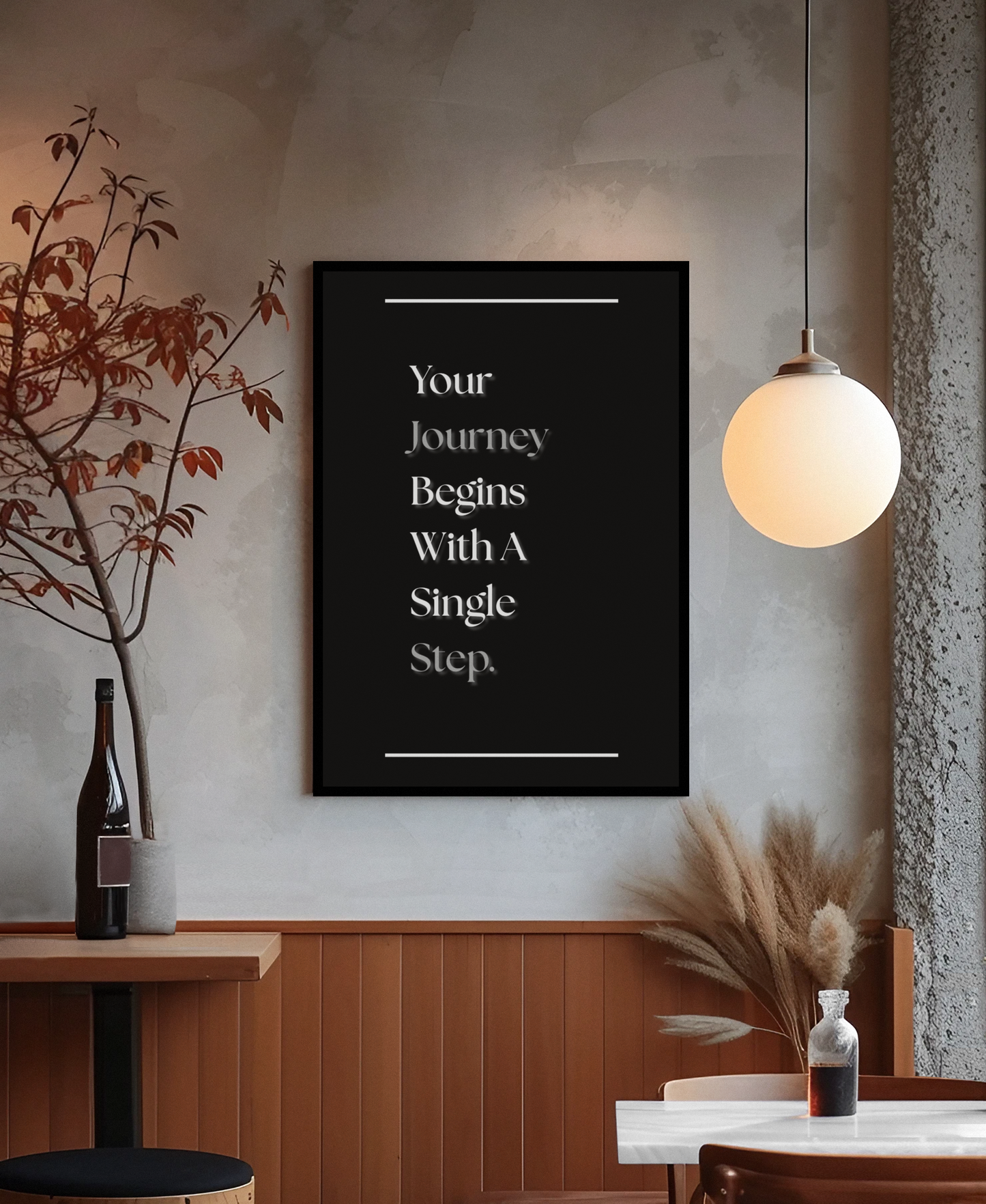A black framed wall art print with white text reading 'Your Journey Begins With A Single Step.' hangs on a textured gray wall in a modern interior setting with a hanging globe lamp, wood paneling, and decorative dried grasses and a bottle.