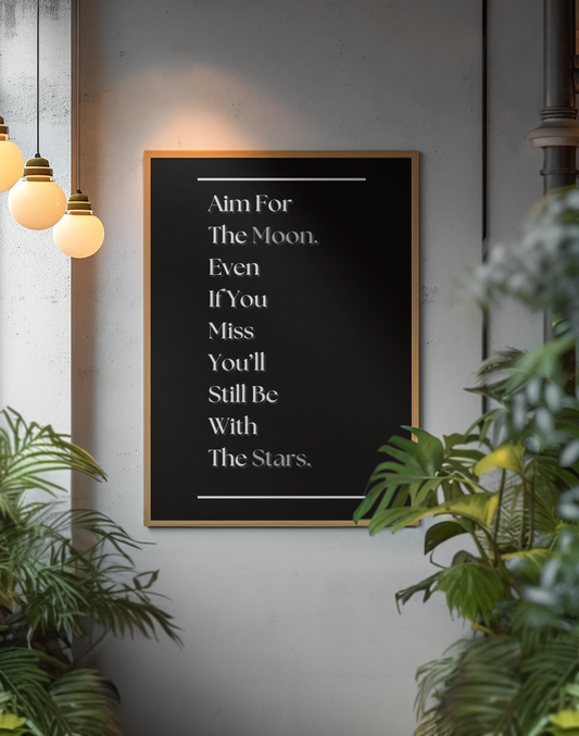 A black framed typographic wall art print with white text reading, 'Aim For The Moon. Even If You Miss You'll Still Be With The Stars.