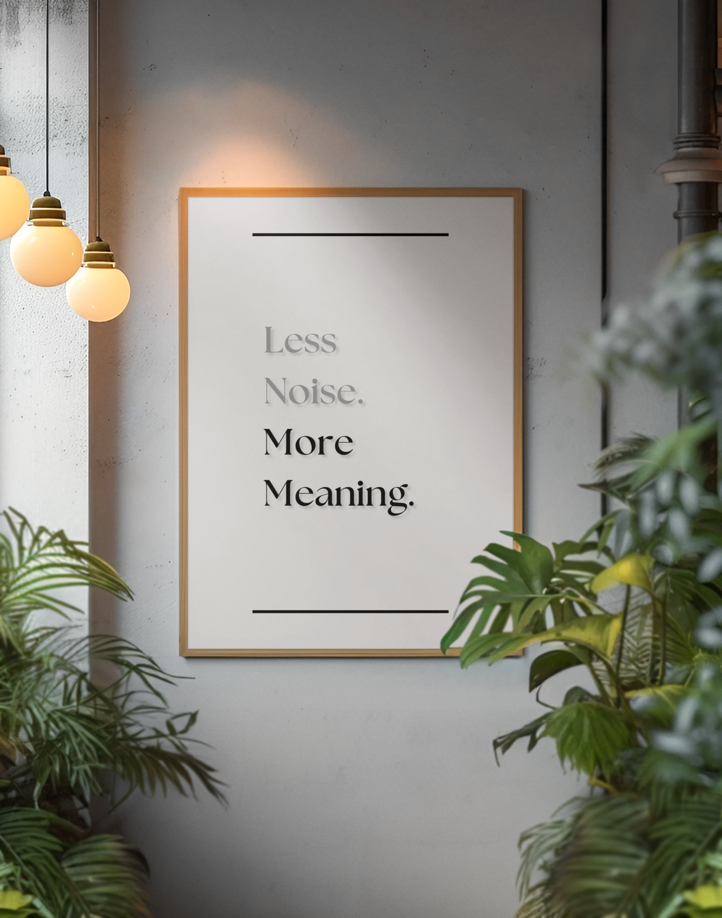 A framed motivational wall art print with the text 'Less Noise. More Meaning.' in white serif lettering on a black background, hanging on a gray wall in a styled interior with hanging pendant lights and green plants.