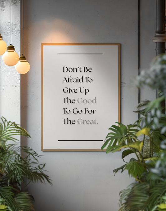A framed motivational wall art print with the quote 'Don't Be Afraid To Give Up The Good To Go For The Great.' displayed on a gray wall, surrounded by green plants and warm hanging pendant lights.