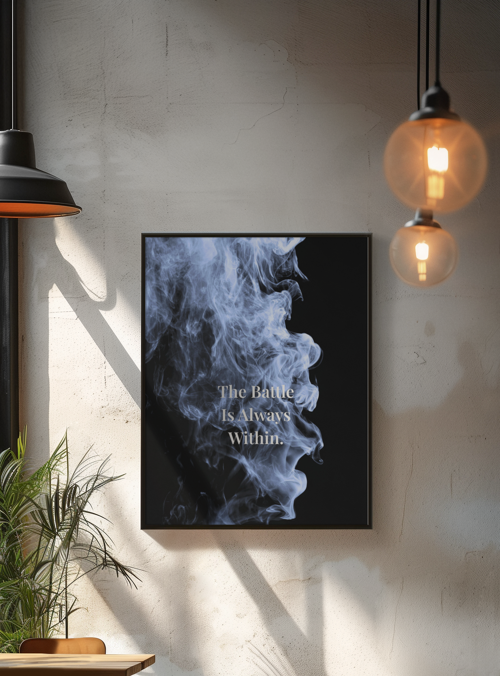 A framed wall art print hanging on a textured light gray wall in a styled interior. The print features a black background with a blue-gray smoke graphic and the text 'The Battle Is Always Within'.