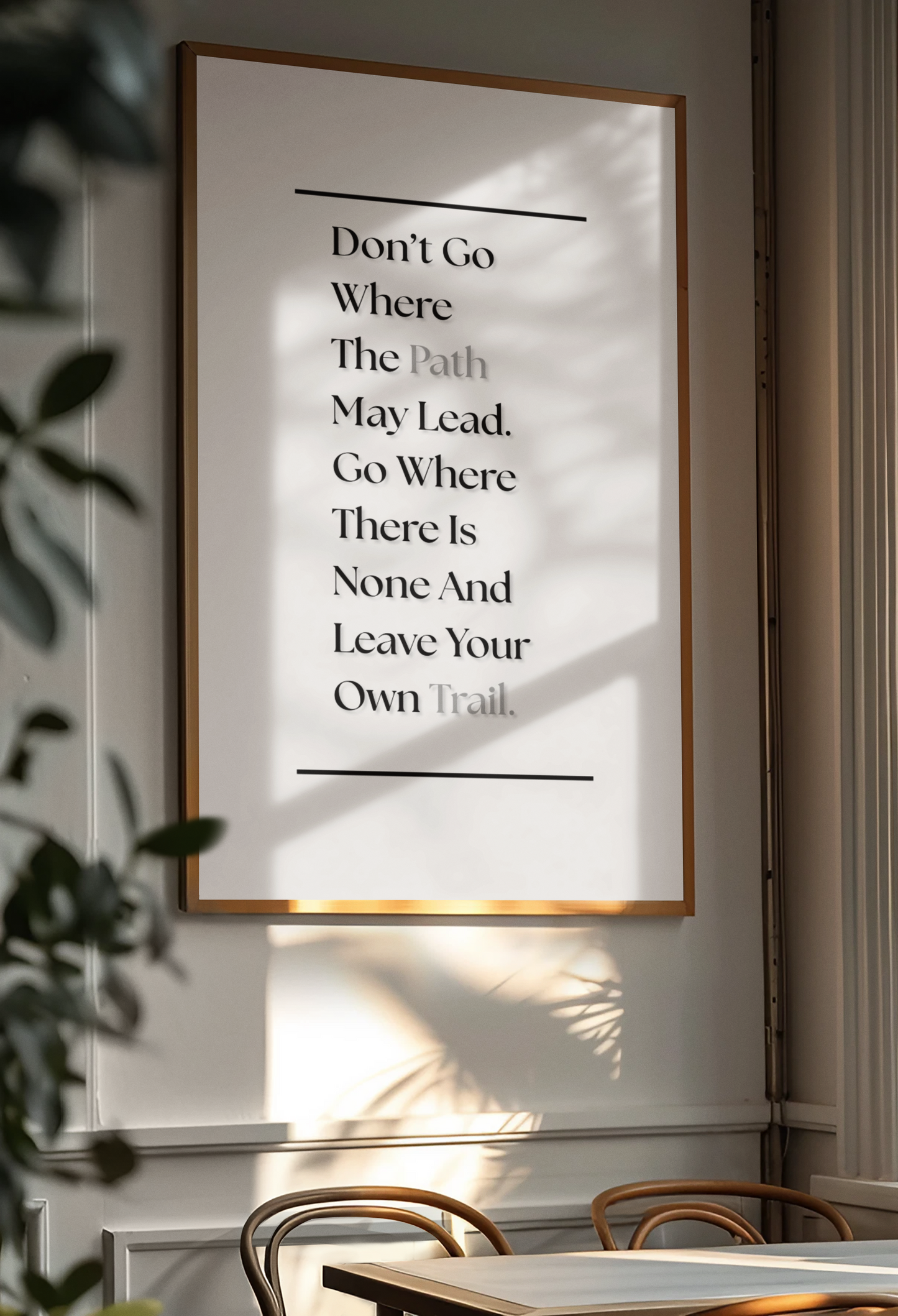 A framed motivational wall art print with a quote about following one's own path, hanging on a wall in a dining room setting with natural light and shadows.