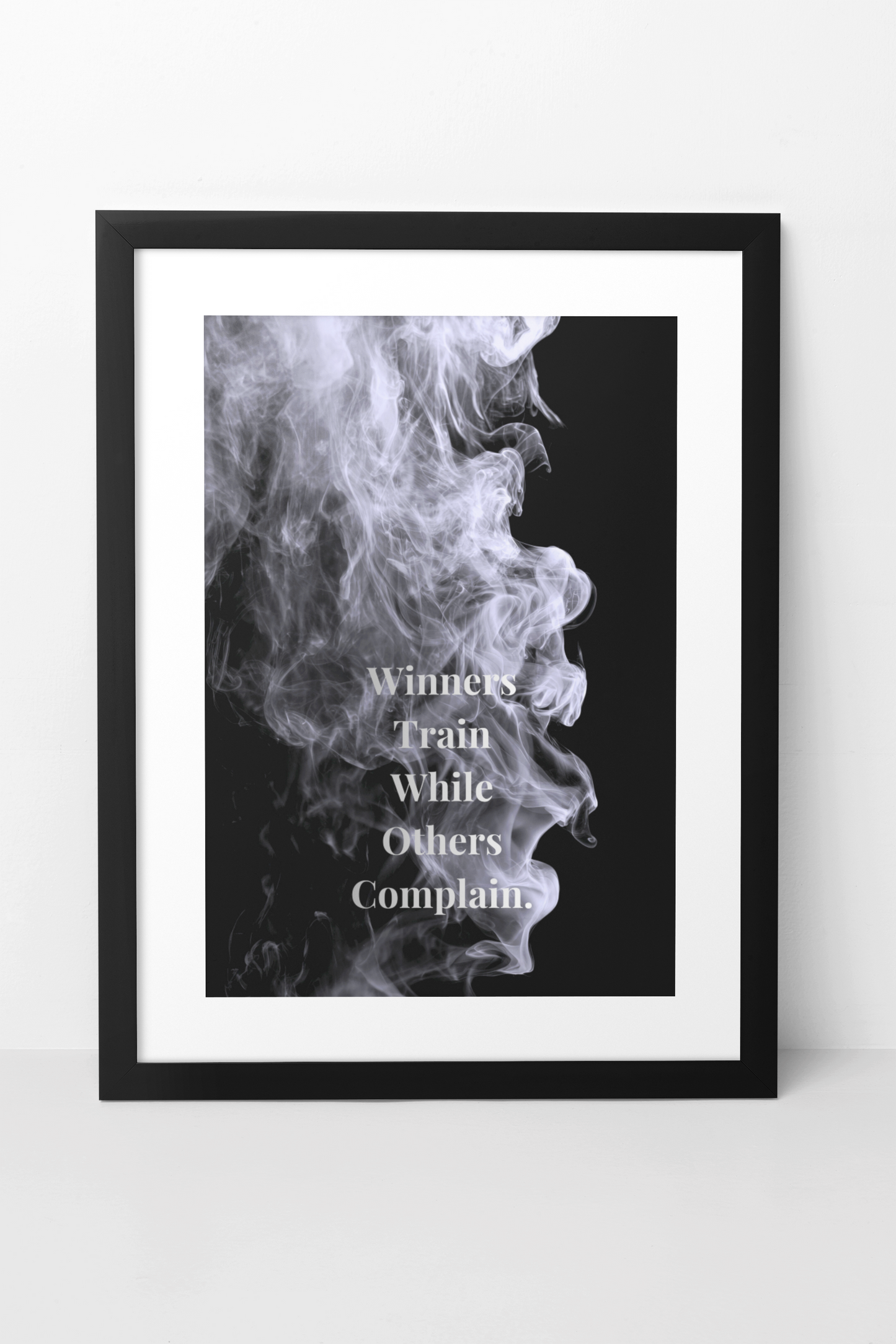 A framed black and white motivational poster featuring a dramatic smoke graphic with the text.