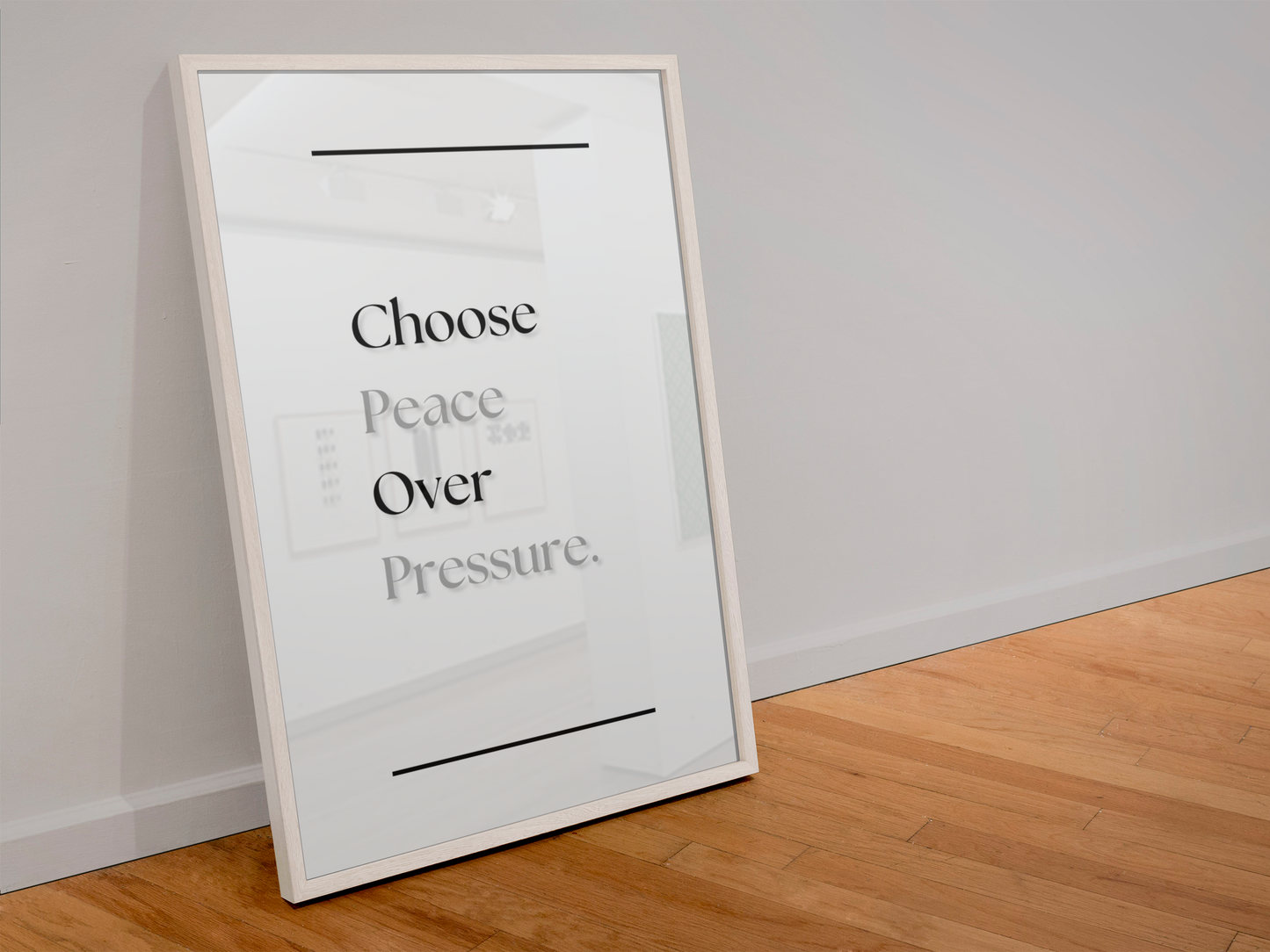 A large framed wall art print leaning against a light gray wall on a wooden floor. The print has a white background with the text 'Choose Peace Over Pressure'.