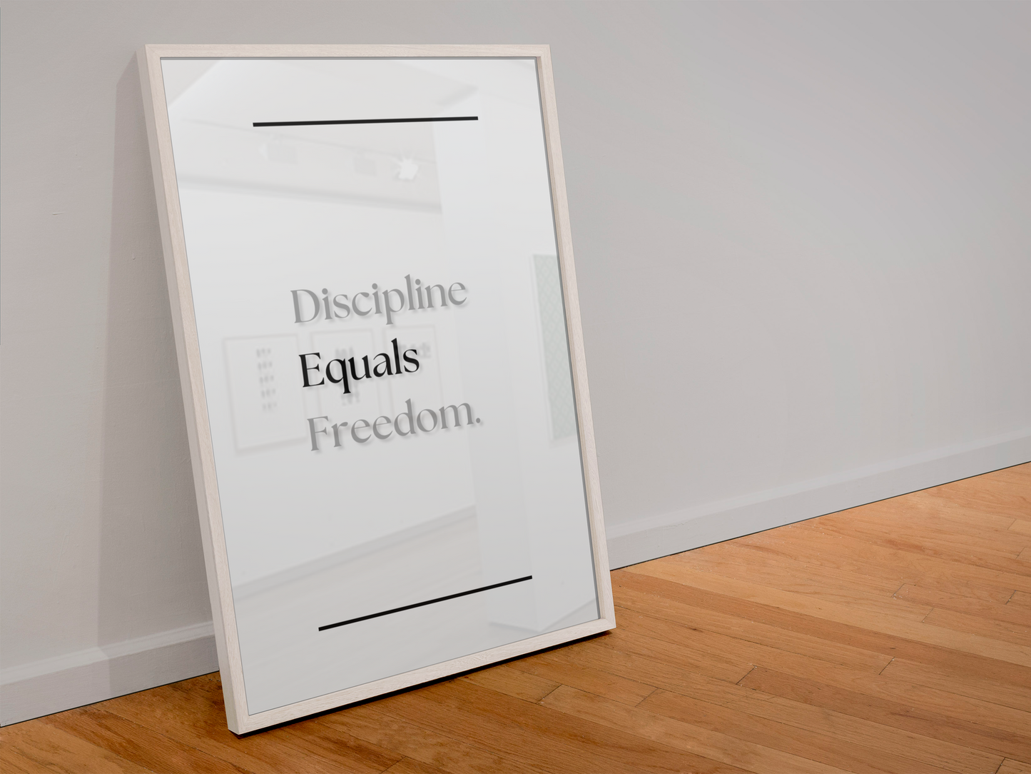 A framed typographic wall art print leaning against a light gray wall on a wood floor. The print has a white background with black text reading 'Discipline Equals Freedom.
