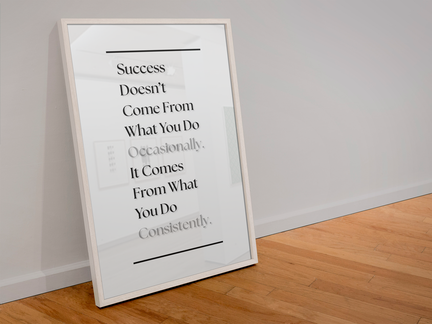 A framed motivational quote print leaning against a white wall on a light wood floor. The print features black serif text on a white background with a thin white frame.