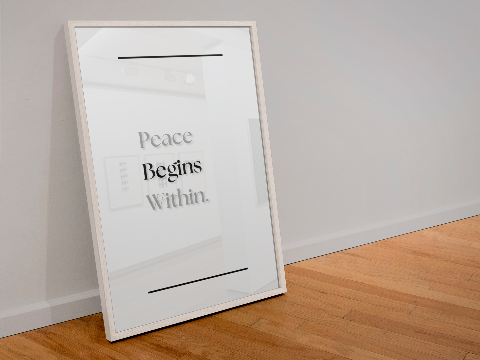 A large framed minimalist art print leaning against a light gray wall on a wooden floor. The print features the text 'Peace Begins Within.