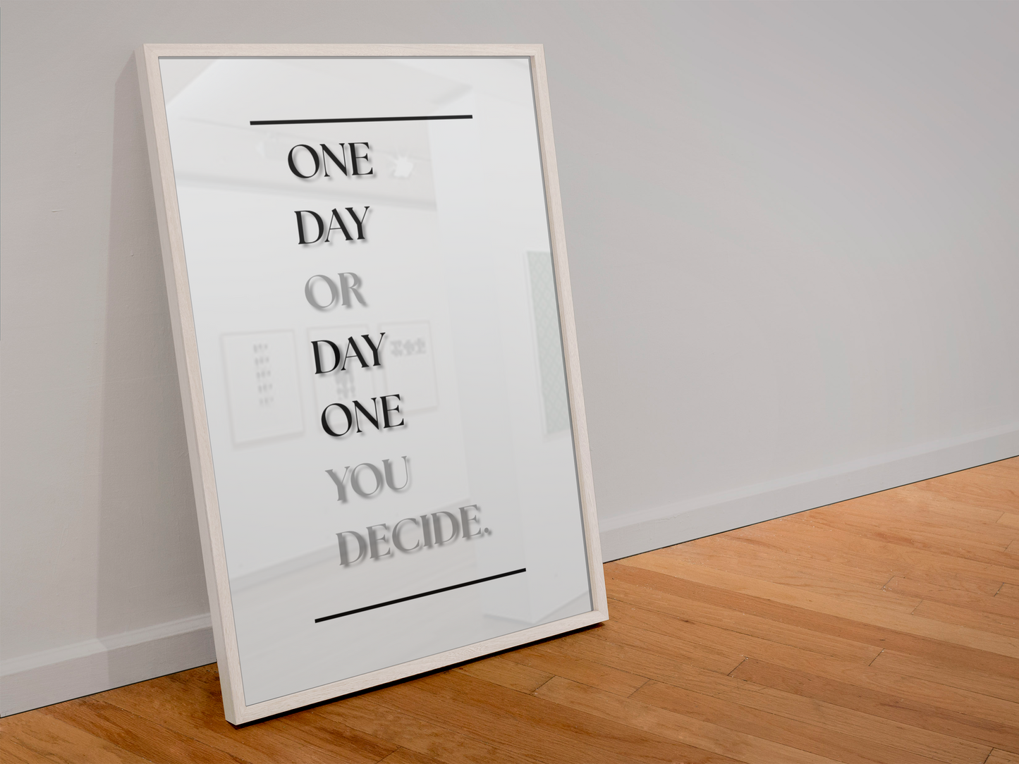 A framed typographic wall art print leaning against a light gray wall on a wood floor. The print reads 'ONE DAY OR DAY ONE YOU DECIDE.'