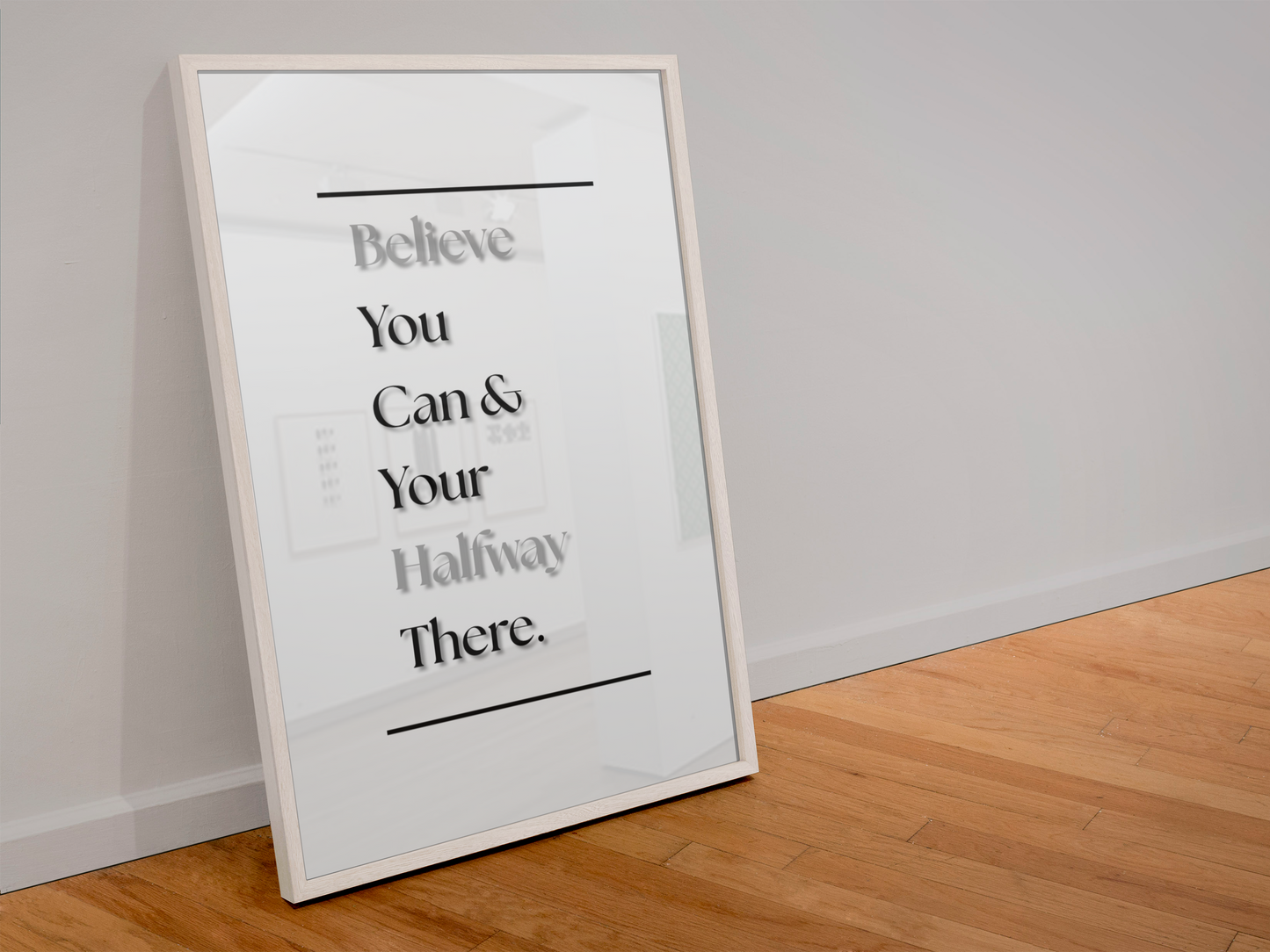 A framed motivational art print leaning against a white wall on a light wood floor. The print features the text 'Believe You Can & Your Halfway There.'