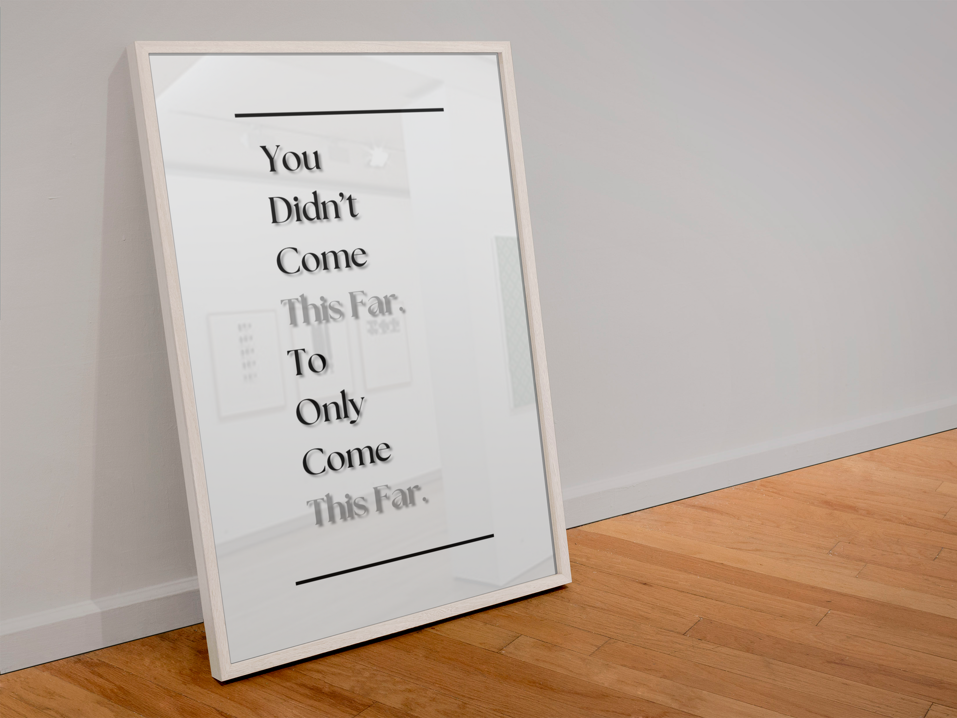 A framed typographic wall art print leaning against a white wall on a light wood floor. The print has black text reading 'You Didn't Come This Far, To Only Come This Far.