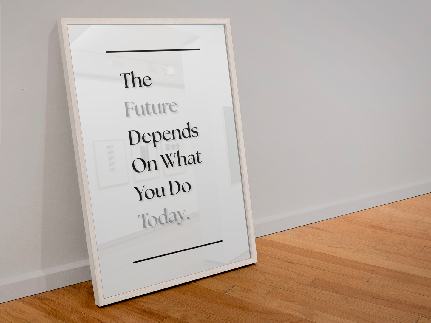 A framed motivational quote print leaning against a white wall on a light wood floor. The print features black serif text reading 'The Future Depends On what You Do Today'.