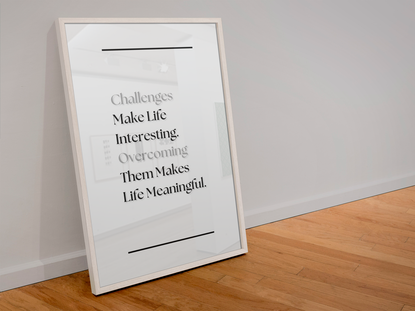 A framed motivational art print leaning against a white wall on a light wood floor. The print features a quote about challenges and life meaning in black serif text on a white background with a thin black border.