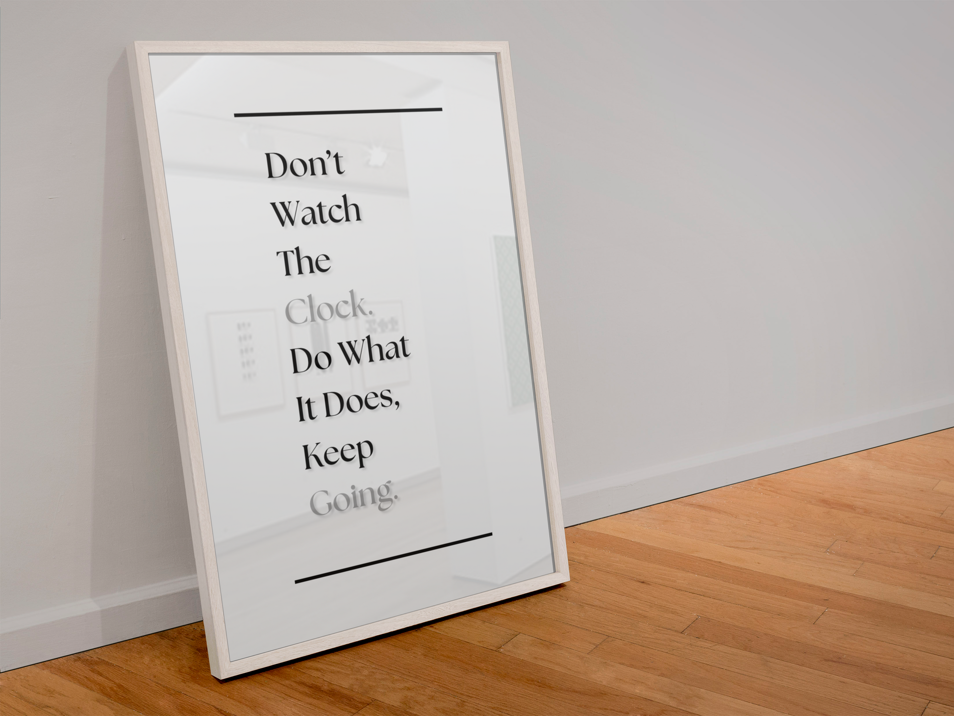 A framed typographic wall art print leaning against a light gray wall on a wood floor. The print features black text reading, 'Don't Watch The Clock, Do What It Does, Keep Going.