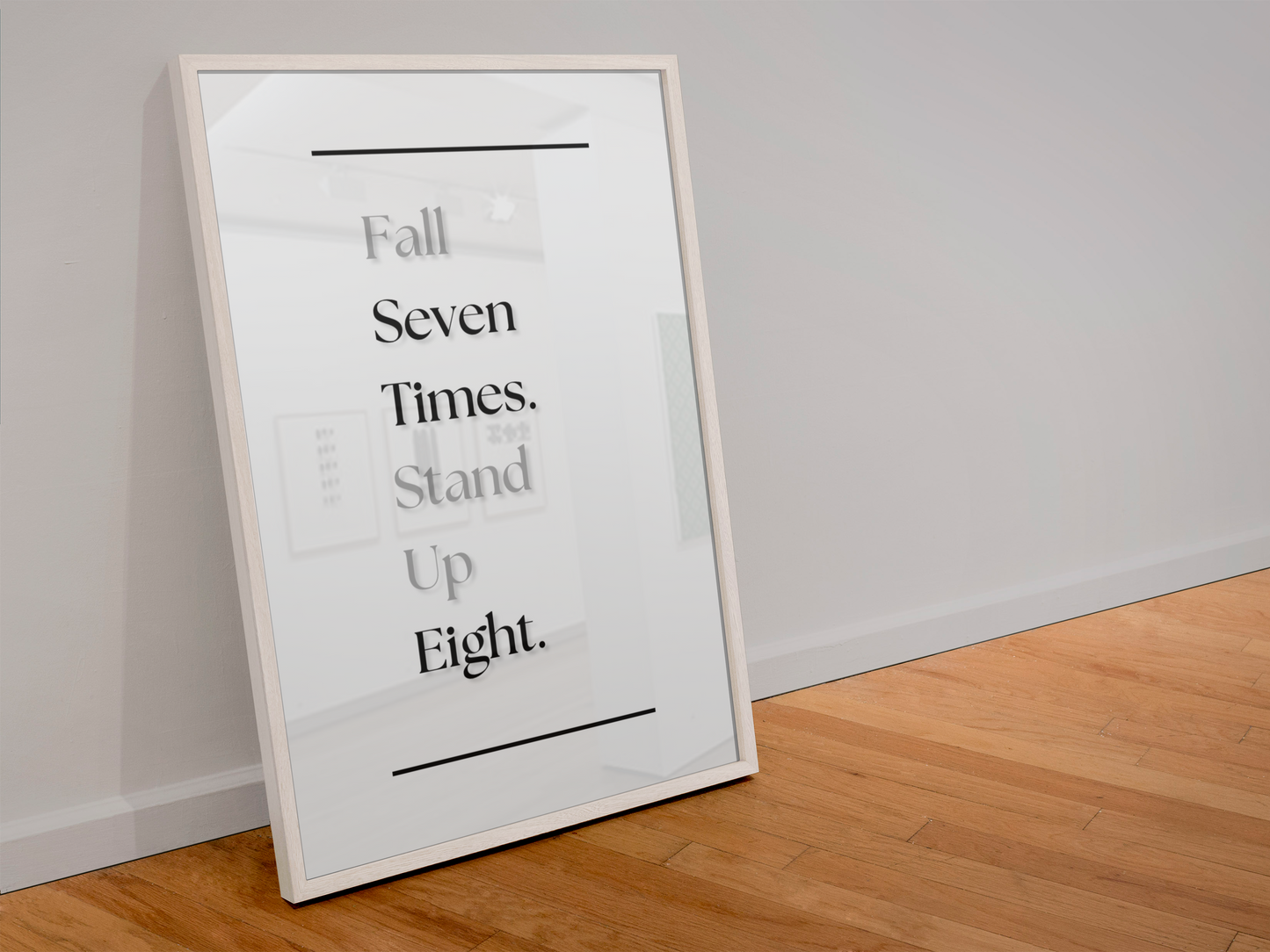 A framed motivational wall art print leaning against a white wall on a light wood floor. The print features the text 'Fall Seven Times. Stand Up Eight'.