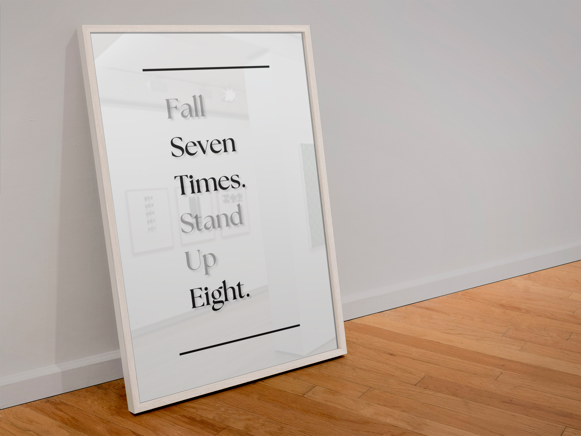 A framed motivational wall art print leaning against a white wall on a light wood floor. The print features the text 'Fall Seven Times. Stand Up Eight'.